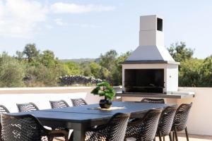 een tafel en stoelen op een patio met een open haard bij Villa Golden Shine in Primošten