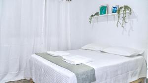 a white room with a bed with towels on it at Estrella de Mar in Pedernales