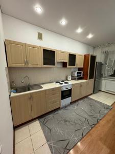 a kitchen with a sink and a stove top oven at Apartments Zhayau Musa 7b in Pavlodar