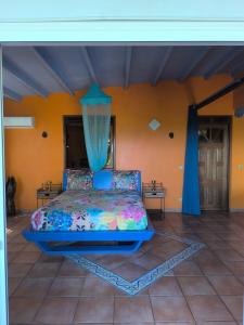a bedroom with a bed with a blue canopy at Concept Kreyol in Sainte-Rose