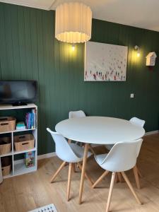 a dining room with a white table and chairs at Mignon petit Studio 25m2 avec balcon et Parking face départ pistes ! in Demi-Quartier