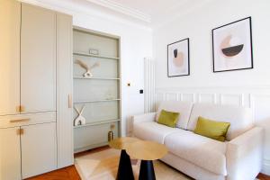 a living room with a white couch and a table at Appartement élégant près de Bastille-Gare de Lyon in Paris