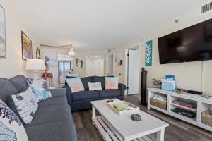 ニュー・スマーナ・ビーチにあるCoastal Paradise - Amazing Ocean Views! Pool - Walk to Shopping and Dining - OT302のソファとテーブルのあるリビングルーム