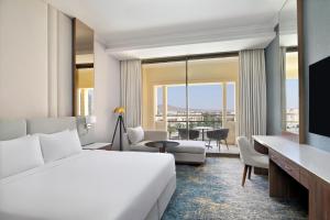 a hotel room with a bed and a living room at Mövenpick Hotel Waad Al Shamal in Ţurayf