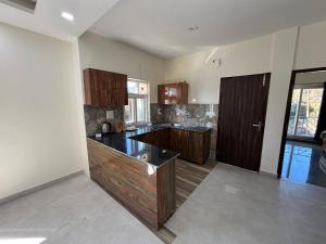 una cocina vacía con armarios de madera y encimera en Shanti Retreat, en Bhimtal