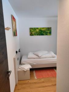 a small bedroom with a bed and a painting on the wall at appartamento PANORAMA in Pozza di Fassa +25 photos