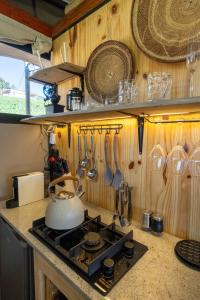 a kitchen with a stove and utensils on a wall at Amperbo Glamping in Cape Town