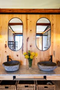two sinks in a bathroom with two mirrors at Amperbo Glamping in Cape Town