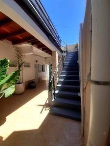 eine Treppe, die zu einem Haus mit blauen Decken führt in der Unterkunft Gotas de Rocio N1 in San Antonio Oeste