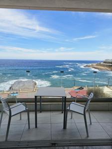 a table and two chairs on a balcony with the ocean at Sea View apartment on Promenade S1 in Sliema +24 photos