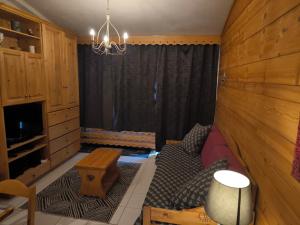 a living room with a couch and a chandelier at Duplex à la Moutière in Tignes