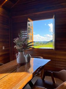 a dining room with a table with a vase of flowers on it at Refúgio Da Lua - Celeiro in Ametista do Sul