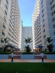 zwei hohe Gebäude mit Palmen in einem Park in der Unterkunft Green 2 SMDC - STUDIO TYPE Condo - Gems Suite Staycation in Dasmariñas + 8 Fotos