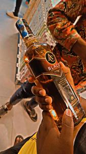 a person is holding up a bottle of alcohol at Untamed developers in Nairobi