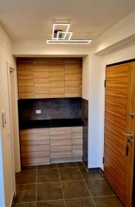 ヤゴディナにあるBeril lux apartmanのウォークインクローゼット(木製のキャビネット、ドア付)