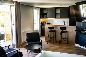 una cocina con bañera y una cocina con taburetes en LOVE ROOM SAUNA,JACCUZZI Netflix Tours, en La Riche