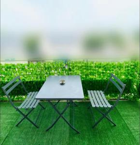 una mesa y dos sillas y un seto con plantas en LOVE ROOM SAUNA,JACCUZZI Netflix Tours, en La Riche