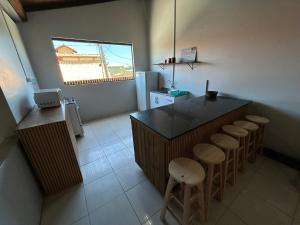 a kitchen with a counter and some stools in it at Complexo Brisa Ferrugem in Garopaba