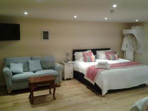 a bedroom with two beds and a couch at The Green Dragon in Market Lavington