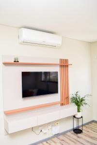 a living room with a television on a wall at Mondjila Apartments in Windhoek