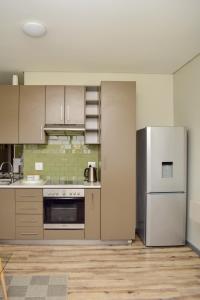 an empty kitchen with stainless steel appliances and wooden floors at Mondjila Apartments in Windhoek