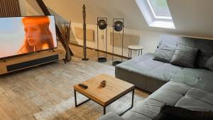 a living room with a couch and a flat screen tv at Forest Loft Apart in Alfeld