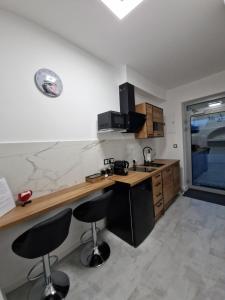eine Küche mit Theke und zwei Barhockern in der Unterkunft Mini Agat in Lwówek Śląski