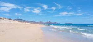 a beach with the ocean and mountains in the background at Villa Ines, at the beach in Porto Santo +22 photos