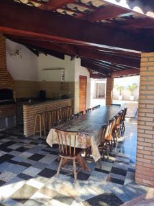 a dining room with a long table and chairs at Rancho Costa in Pereira Barreto