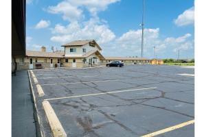 a parking lot with a car parked in front of a building at Budget Inn motel toledo perrysburg I-280 in Millbury