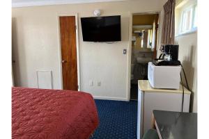 a hotel room with a bed and a flat screen tv at Budget Inn motel toledo perrysburg I-280 in Millbury +35 photos