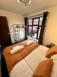 a bedroom with a large bed with two towels on it at Archway House - City Townhouse Sleeps 7 Free Private Driveway Parking For Up To 2 Cars in Norwich