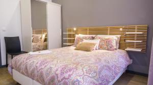 Un dormitorio con una cama grande y una silla. en Cilio House, en Ponta Delgada