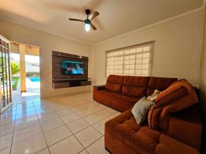 un soggiorno con divano e TV a schermo piatto di Linda casa 5 quartos prox a av cataratas e centro a Foz do Iguaçu