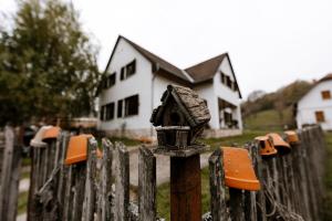 ÓbányaTaurus Vendégház的房子前面有一道栅栏,栅栏上挂着一个鸟屋。