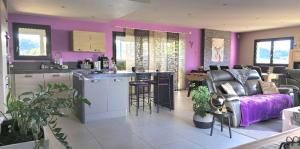 d'une cuisine et d'un salon aux murs violets. dans l'établissement spa de nage et jacuzzi à Séverac d'Aveyron, à Sévérac d' Aveyron
