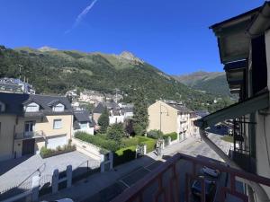 - un balcon offrant une vue sur une ville avec des montagnes dans l'établissement Appartement à Cauterets avec parking privé et coin montagne - FR-1-812-34, à Cauterets