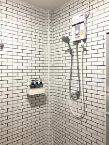 y baño con ducha de azulejos blancos y secador de pelo. en Breeze House Downtown Chatuchak, Lat Phrao, en Bangkok 33 fotos más