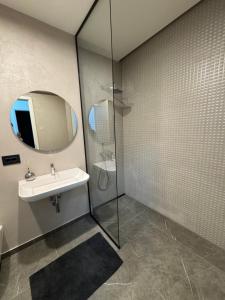 a bathroom with a sink and a shower with a mirror at Elite Kasper in Braşov