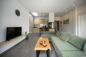 a living room with a green couch and a table at Modern Spacious Apartment in Kissamos