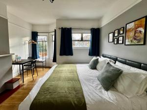 a bedroom with a large bed with blue curtains at Maberic Housing West London Gem Your Central London Connection in London