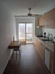 a kitchen with a table and a sink and a window at City Centre apartments in Denia