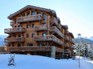 a large wooden apartment building in the snow at Magnifique duplex 3 chambres à Courchevel avec balcon, parking, et WIFI - FR-1-575-107 in Courchevel