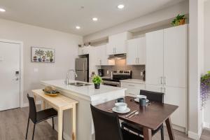 a kitchen with white cabinets and a table and chairs at Free Parking, Close to Downtown, Pet Friendly in Calgary