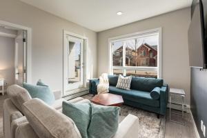 a living room with a blue couch and two windows at Free Parking, Close to Downtown, Pet Friendly in Calgary