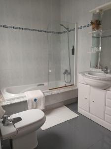 a bathroom with a shower and a toilet and a sink at Brañas Home in Cambados +46 photos