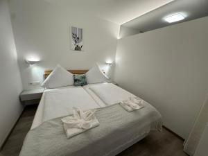 a bedroom with a bed with white sheets and bows at Apartment Zoe in Zell am See