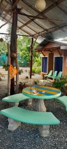 a patio with a table and chairs under a pavilion at La Chonta de Corcovado in Puerto Jiménez