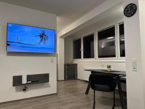 a living room with a table and a tv on the wall at Apartment Zoe in Zell am See