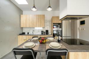 a kitchen with a table with chairs and a counter top at Modern Spacious Apartment in Kissamos
